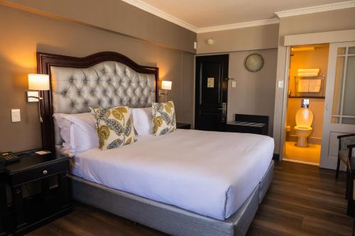 a bedroom with a large white bed in a room at Premier Hotel Cape Town in Cape Town