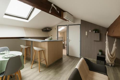 une cuisine et un salon avec une table et des chaises dans l'établissement Sous les toits, à Narbonne