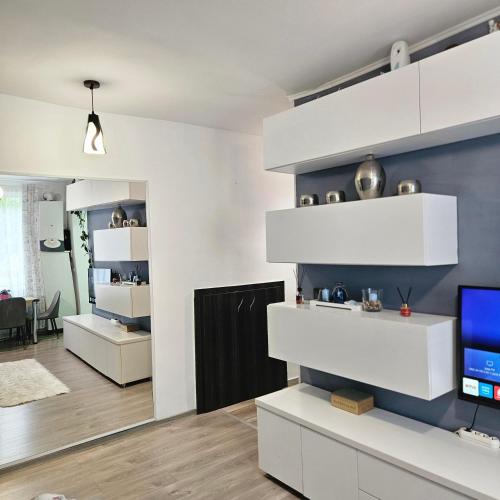 a living room with white shelves and a tv at Apartament Zarnesti free parking VMP 2 in Zărneşti