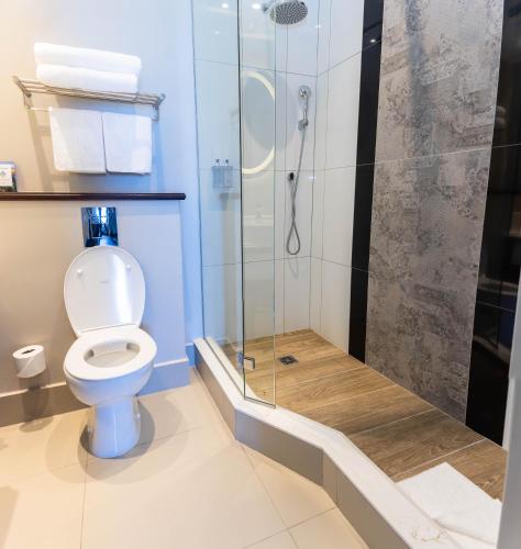 a bathroom with a toilet and a glass shower at Premier Hotel Cape Town in Cape Town