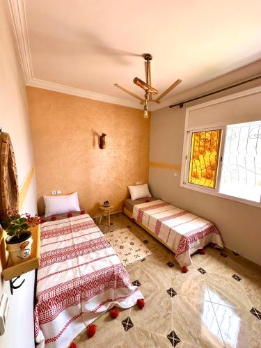 a bedroom with two beds and a window at Balance Surf Morocco , Quality rooms , Moroccan food , Activities in Aourir