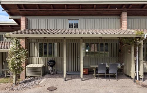 un porche cubierto con mesa y sillas en 2 Bedroom Stunning Home In Allinge, en Allinge