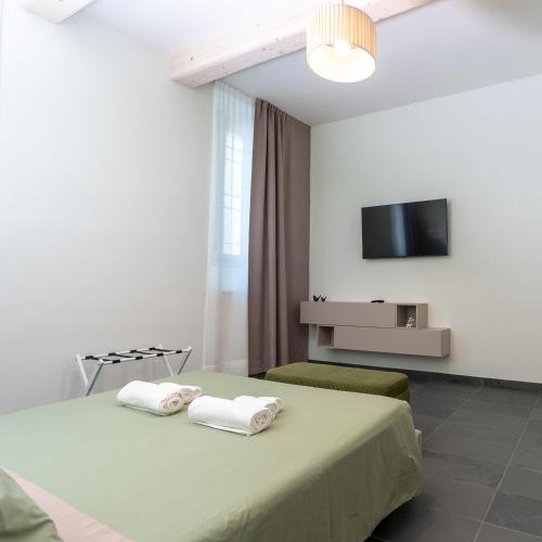 a bedroom with a bed and a tv on the wall at Antica Corte Lugo in Lugo