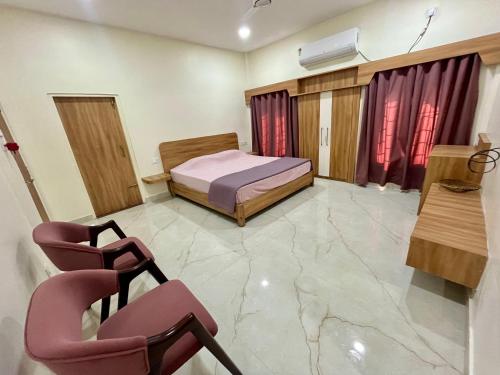 Un dormitorio con una cama y una silla dentro. en ClubGreens, en Jorhat