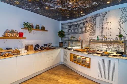 a kitchen with white cabinets and a drawing on the wall at SH Ingles Boutique Hotel in Valencia