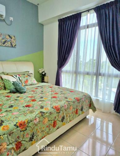 a bedroom with a bed with a floral comforter and a window at RinduTamu Homestay in Lumut