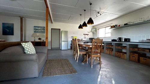 a living room and kitchen with a table and chairs at Blombos Self-Catering House in Franskraal
