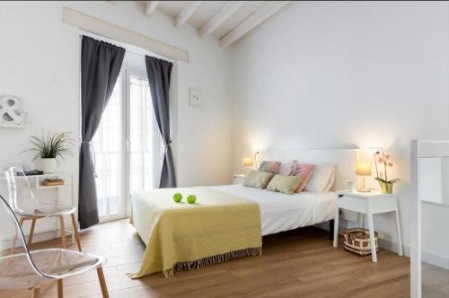 a white bedroom with a white bed and a window at Bajo Gerona in Seville