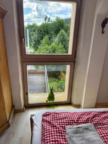 a bedroom with a large window and a green toy at Wohnung 3 in Burghaslach