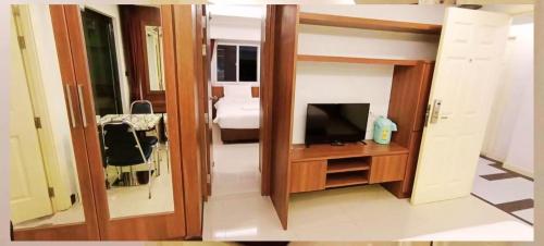a small room with a television and a bedroom at B-your home Hotel Don Mueang Airport Bangkok 如你家酒店 in Bangkok