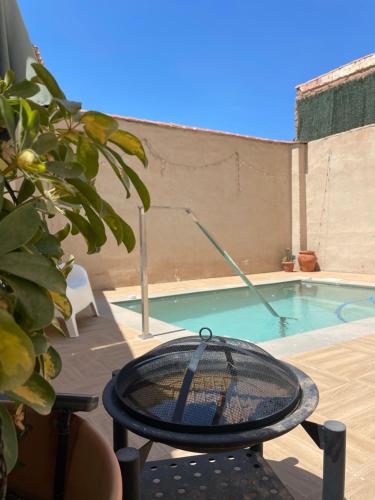 a tennis racket on a table next to a swimming pool at La Casa De Los Gatetes in Dúrcal