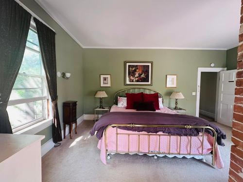a bedroom with a large bed with red pillows at Franklin Manor Bed and Breakfast in Saranac Lake