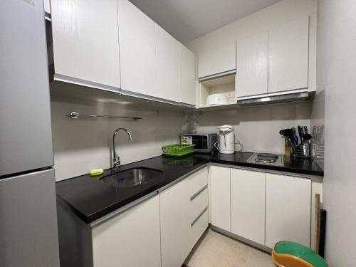 a small kitchen with white cabinets and a sink at Oceanview Condo in Boracay in Boracay