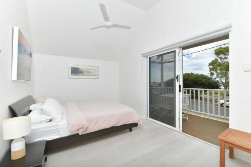 Un dormitorio blanco con una cama y un balcón. en Beach Side Getaway- Free WIFI, en Dunsborough