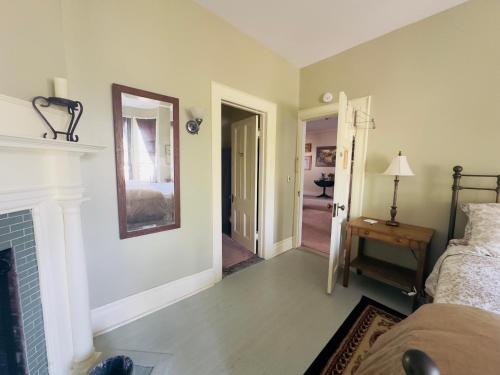 a living room with a fireplace and a bedroom at Franklin Manor Bed and Breakfast in Saranac Lake