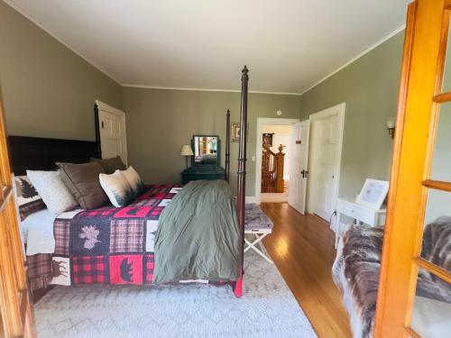 a bedroom with a bed and a mirror at Franklin Manor Bed and Breakfast in Saranac Lake