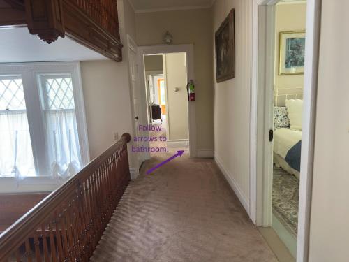 a hallway with a stairway leading to a bedroom at Franklin Manor Bed and Breakfast in Saranac Lake