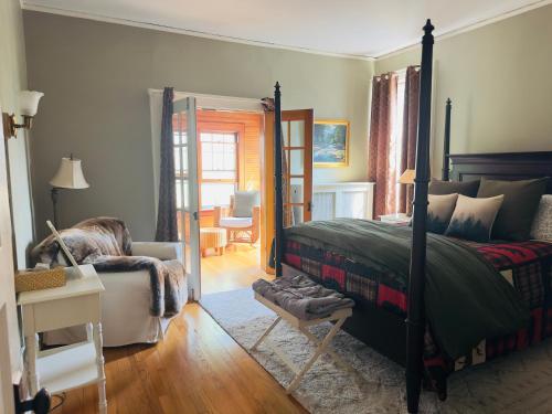 a bedroom with a bed and a chair and a mirror at Franklin Manor Bed and Breakfast in Saranac Lake