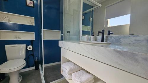ein blaues Badezimmer mit Toilette und Waschbecken in der Unterkunft ensueños in Búzios
