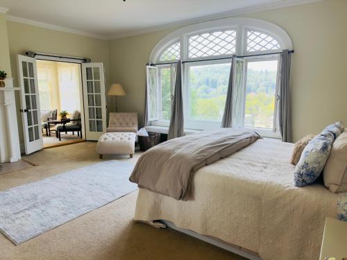 a bedroom with a large bed and a large window at Franklin Manor Bed and Breakfast in Saranac Lake