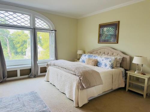 a bedroom with a bed and a large window at Franklin Manor Bed and Breakfast in Saranac Lake