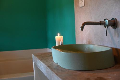 a bathroom sink with a candle on a counter at Casa Colorida in Santa Marta