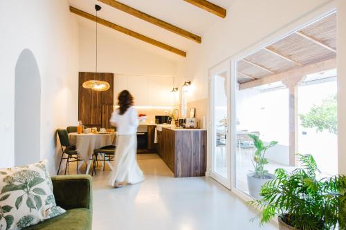 a woman in a white dress is standing in a kitchen at Casa Maria Avieira in Azinhaga