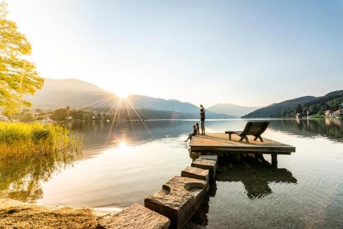 a man standing on a dock on a lake at 3Traumhaftes Ferienhaus in bester Lage in Döbriach