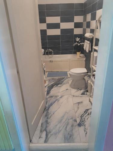 a bathroom with a marble floor and a toilet at Alanis in Vela Luka