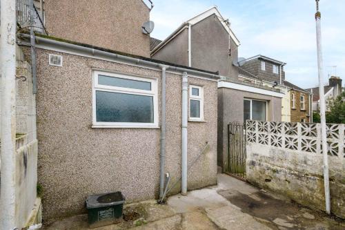 a brick house with a window and a fence at Spacious 3 Bedroom Home in Central Skewen in Skewen
