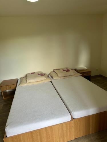 two twin beds in a room with two tables at Selský Dvůr Perštejn in Pürstein