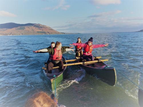 a group of people in a boat in the water at Rostrevor Mountain Lodge - Glamping Pods - Revive Sauna & Hot Tubs in Rostrevor