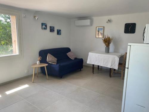 a living room with a blue chair and a table at Au coeur de l'oliveraie in Draguignan