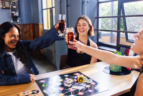 a group of people sitting around a table drinking beer at Stayokay Hostel Eindhoven in Eindhoven