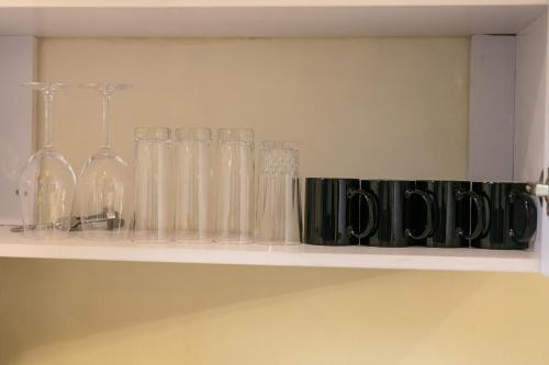 a shelf with glasses and bottles on it at Elysian lux home in Kampala