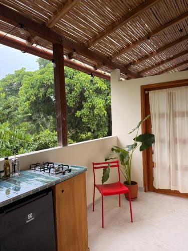a kitchen with a stove and a red chair at Casa Colorida in Santa Marta