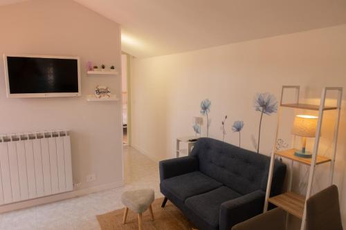 Una sala de estar con un sofá y un televisor en la pared. en Casa Gioia, en Marcelli