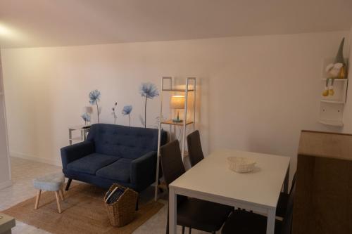 Una sala de estar con un sofá azul y una mesa. en Casa Gioia, en Marcelli