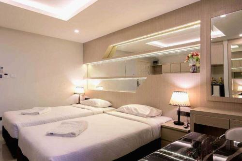 a hotel room with two beds and a sink at B-your home Hotel Don Mueang Airport Bangkok 如你家酒店 in Bangkok
