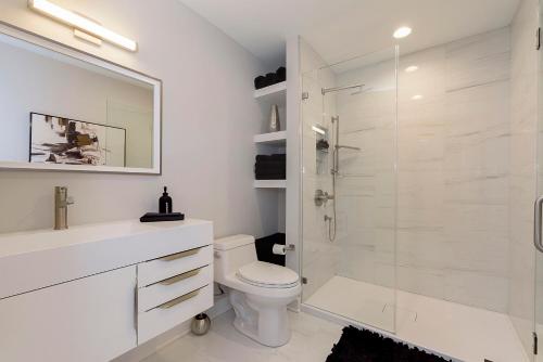 Un baño blanco con inodoro y ducha. en Indy Pool Home, en Indianápolis