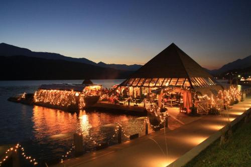 a large building with lights in the water at night at 4Luxuriöses Ferienhaus in traumhafter Landschaft in Döbriach