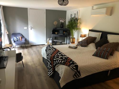 a bedroom with a large bed with pillows on it at Mawosy Lodge in Apeldoorn