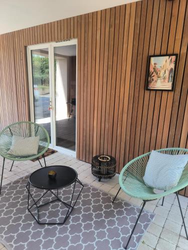two chairs and a table on a patio at Ancienne grange rénovée in Bellengreville