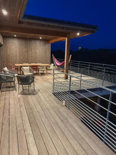 a deck with chairs and a table and a hammock at Villa Ondella - Villa entre plages et sentiers in Pianottoli-Caldarello