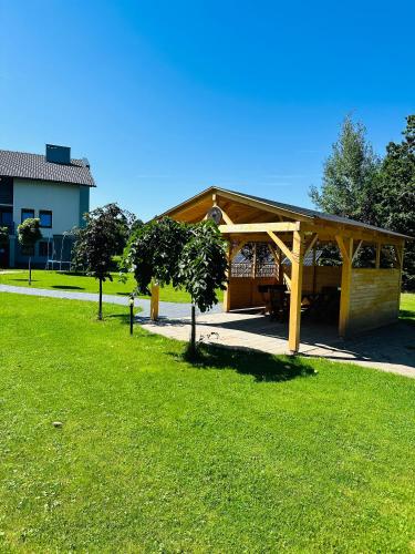 a wooden pavilion in a park with green grass at Willa Czajki in Oświęcim