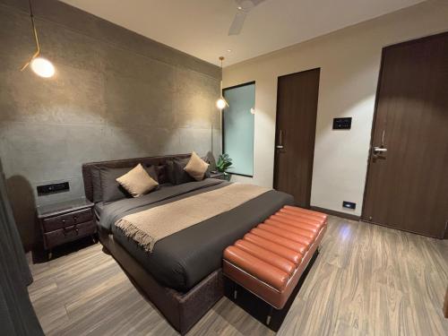 a bedroom with a bed and a leather bench at Dolce Villa IGATPURI in Igatpuri