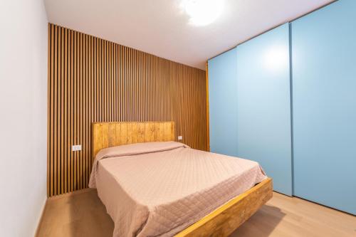 a bedroom with a bed and a wooden wall at casa laura in Olbia