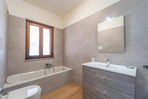 a bathroom with a sink and a tub and a toilet at casa laura in Olbia