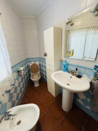 a blue and white bathroom with a sink and a toilet at La Casa De Los Gatetes in Dúrcal