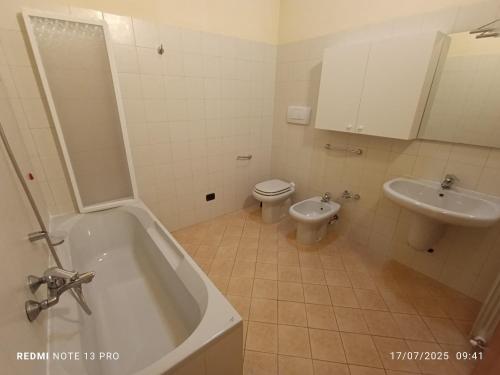a bathroom with a tub and a toilet and a sink at Villa Mattia in Edolo